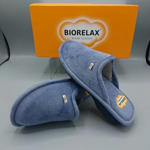 Pantuflas de la marca Biorelax en color azul, con un diseño cómodo y suave, junto a su caja de presentación. Ideal para el descanso y el confort del hogar.