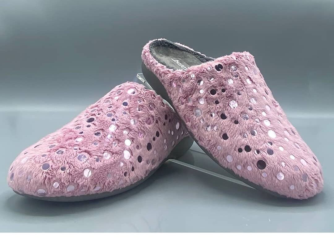 Zapatillas de casa de color rosa con textura suave y detalles brillantes, ideales para un estilo cómodo y moderno en el hogar.